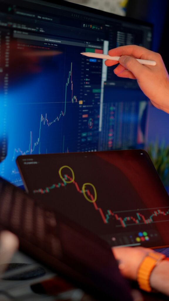 Analyse de données financières sur tablette et écran de monitoring dans un environnement professionnel