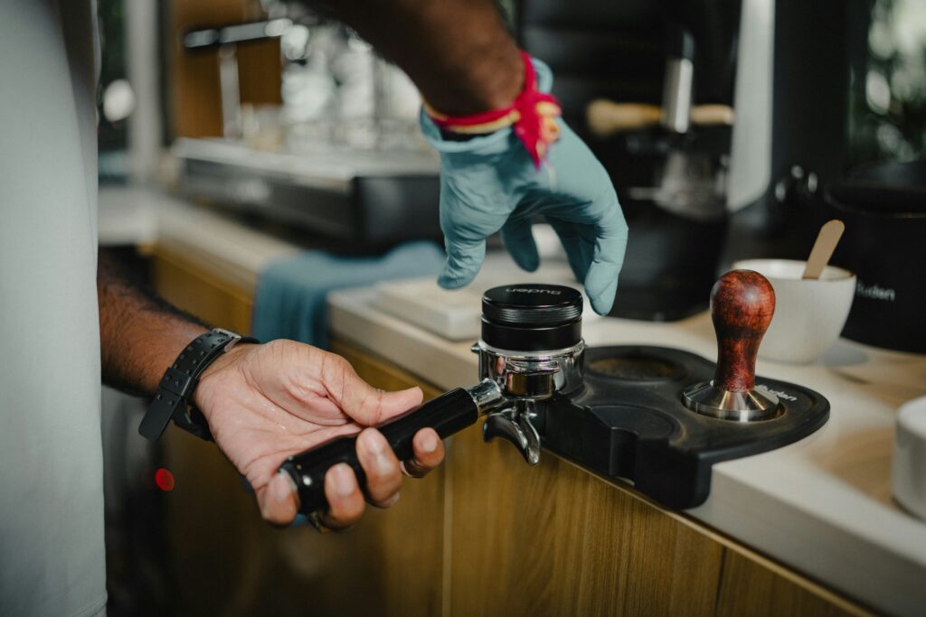 Préparation technique de l'espresso : dosage et tassage du café moulu dans le porte-filtre