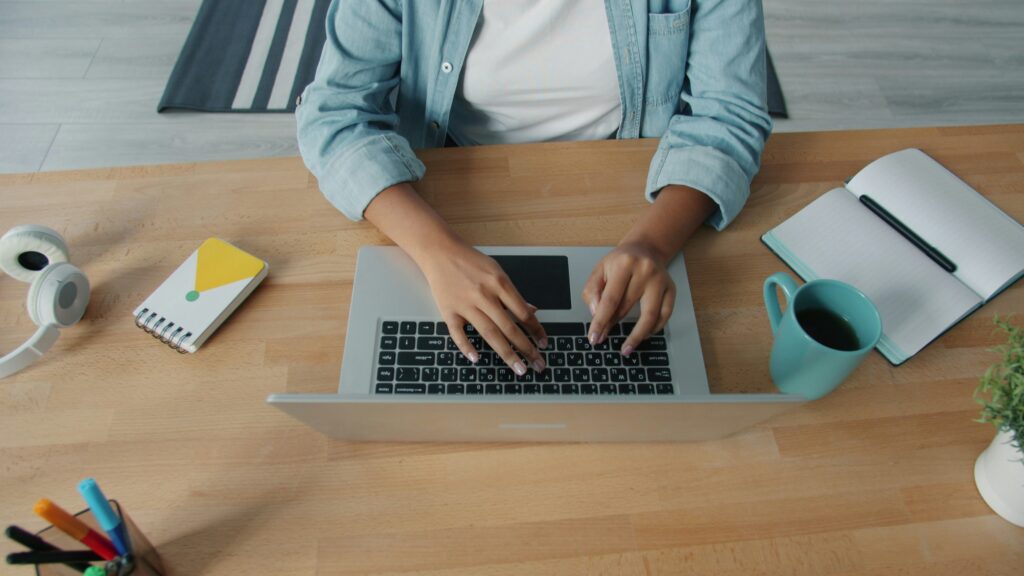 Espace de travail avec café, ordinateur portable et carnets, évoquant la pause contemplative du dégustateur