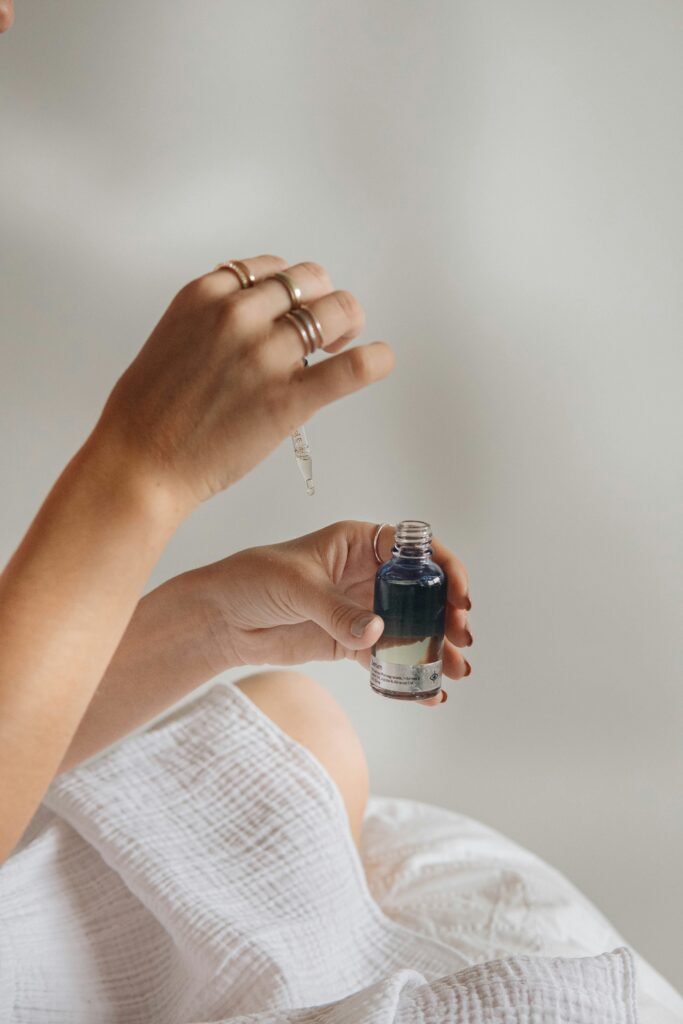 Application du sérum Nūde avec pipette, démontrant l'utilisation du système rechargeable